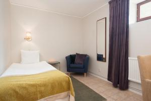 特罗尔海坦西贡奥斯卡克拉丽奥连锁酒店的一间卧室配有一张床和一张蓝色椅子