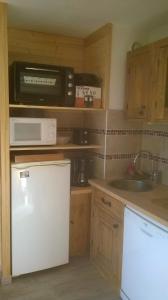 丰罗穆Appartement Pyrénées 2000的厨房配有白色冰箱和微波炉