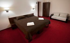 哈尔科夫12酒店的一间卧室配有一张床,上面有两条毛巾