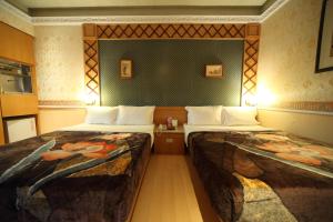 Qishan玫瑰花园汽车旅馆 的一间酒店客房,房间内设有两张床