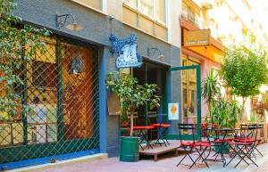 雅典雅典联结公寓的大楼外的咖啡馆,带桌椅