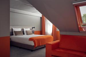Oost亨德里克特克塞尔王子酒店的一间卧室配有一张床和一张红色椅子