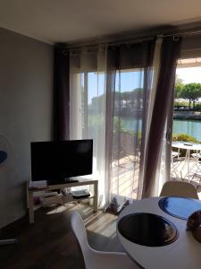 圣普里安海滩Marina village的一间带电视和大窗户的客厅