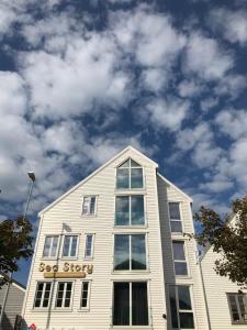 斯塔万格Sea Story by Frogner House的白色的建筑,上面有标志