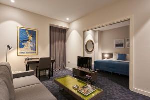 阿尔及尔M Suite Hotel的酒店客房设有沙发、床和桌子。