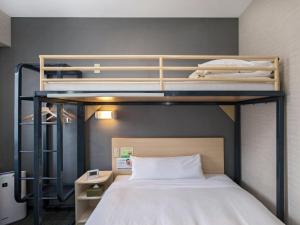 松本松本站前超级酒店的小型客房配有2张双层床和1张床