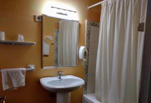 昆卡佩德罗托雷斯酒店的一间带水槽、镜子和淋浴的浴室