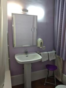 昆卡佩德罗托雷斯酒店的一间带水槽、镜子和凳子的浴室