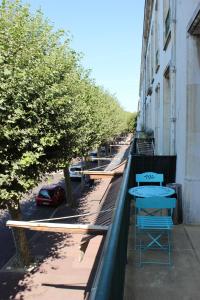 鲁瓦扬Tout A Pied Au Coeur De Royan的街边的阳台,配有两张桌子和树木