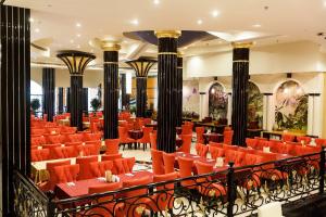 沙迦Red Castle Hotel的大楼内一家带橙色椅子和桌子的餐厅