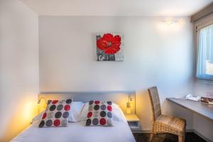 默兹河畔凡尔登Les Orchidées , Hôtel & Restaurant的卧室配有一张挂着红花的床。