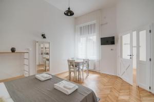 布达佩斯利兹玛丽之仙境公寓的一间白色的房间,配有桌子和饭厅