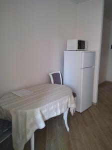 布恰Подобово апартаменти в м Буча的小房间设有桌子和白色冰箱