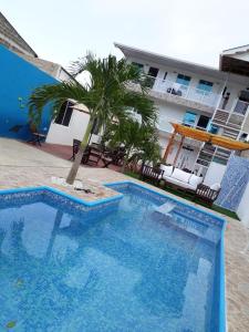 圣安德烈斯Apartamentos Isla Tropical的一座蓝色的游泳池,在一座建筑前有棕榈树