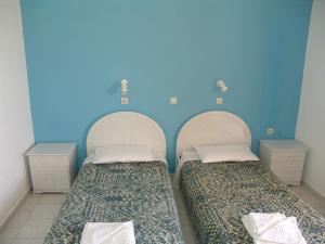 凯法洛斯Kontessa Apartments的蓝色墙壁客房的两张床