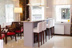 罗萨里奥1412精品酒店 的厨房设有白色椅子和酒吧