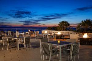 代托纳海滩代托纳海滩硬石酒店 的一个带桌椅的庭院,晚上则享有海景