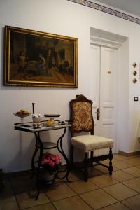 StreviBed And Breakfast Il Garoch的配有桌子、椅子和绘画的房间