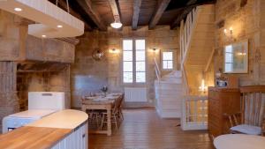 圣西普里安Rue Bertrand de Got的厨房以及带桌子和楼梯的用餐室。