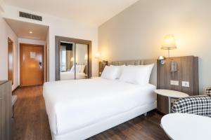 拉科鲁尼亚Eurostars Atlántico的一张大白色的床,位于酒店客房内