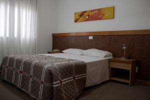 新汉堡市Apto no Union Residence的一间卧室配有一张大床和木制床头板