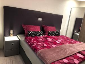 森海姆Am Weinberg的卧室配有一张大床,配有粉色床单和枕头