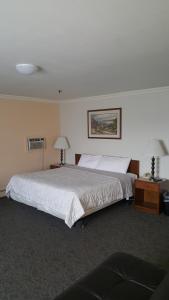 安克雷奇梅丽尔菲尔德酒店的一间卧室设有一张大床和两个床头柜