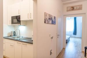 格拉茨Minihotel Graz Apartments的厨房配有白色橱柜和水槽