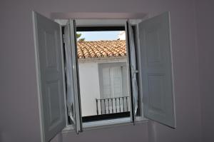 埃武拉A Casa do Mestre的享有屋顶景致的开放式窗户