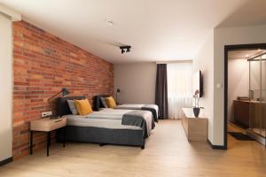 绿山城Apartamenty Centrum Park的一间卧室设有两张床和砖墙