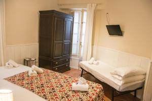 塞维利亚水巷旅馆的客房设有两张床、一个橱柜和一台电视机。