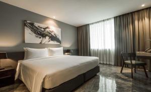 曼谷爵世曼谷酒店的酒店客房设有一张大床和一张书桌。