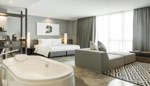 曼谷爵世曼谷酒店的带浴缸和床的酒店客房