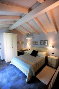坎诺比奥B&B Villa Dei Pini的一间带一张大床的卧室,位于一个拥有木制天花板的房间