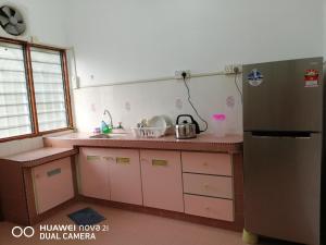 太平Taiping Guest House的厨房配有粉红色橱柜和冰箱