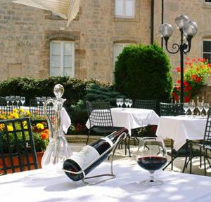 朗格勒Logis Hôtel Le Cheval Blanc的一张桌子,上面放着一瓶葡萄酒和一杯
