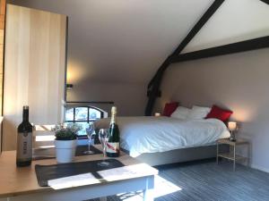 Sart-Dames-AvelinesGîtes du Golf的一间卧室配有一张床和一张带葡萄酒瓶的桌子
