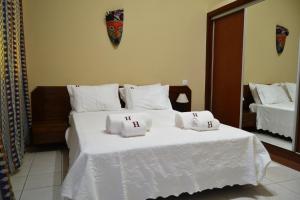 圣多美Hotel Central的一张白色的大床,上面有两个白色的枕头