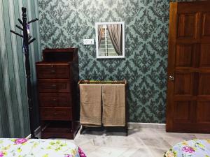 乔治市Bayan Baru Homestay @ Taman Sri Nibong的一间卧室配有绿色壁纸、梳妆台和镜子