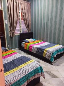 乔治市Bayan Baru Homestay @ Taman Sri Nibong的两张床位于带窗户的房间内