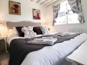 Berville-sur-MerLa Romance et la Romanesque的卧室配有带毛巾的大型白色床