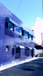 马塞约POUSADA OLÍMPIA的蓝色砖砌建筑的侧面设有阳台