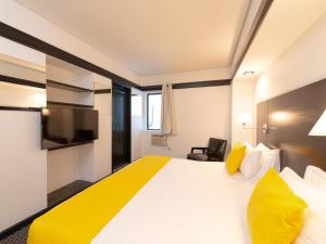 圣保罗Hotel Normandie的酒店客房配有一张带黄色枕头的大型白色床。