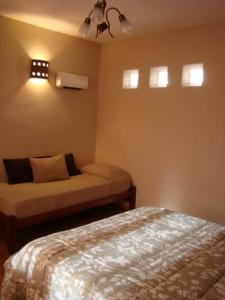 蒂尔卡拉Rinconcito en Tilcara的一间卧室配有一张床和一张小床,铺有四柱床。