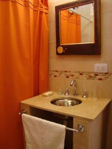 蒂尔卡拉Rinconcito en Tilcara的浴室设有水槽和橙色淋浴帘