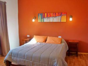 蒂尔卡拉Rinconcito en Tilcara的一间卧室配有一张橙色墙壁的床
