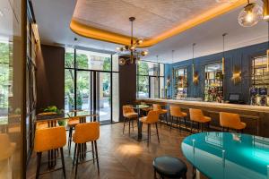圣塞瓦斯蒂安Room Mate Gorka的餐厅设有酒吧,配有橙色椅子和桌子