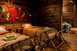 埃普延Las Pitras Lodge的一间设有两张床的客房,墙上挂着一幅画