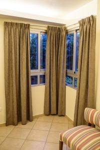 波萨达斯AVEMAR Apart Hotel的客厅设有2扇带窗帘的窗户