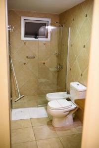 波萨达斯AVEMAR Apart Hotel的一间带卫生间和玻璃淋浴间的浴室